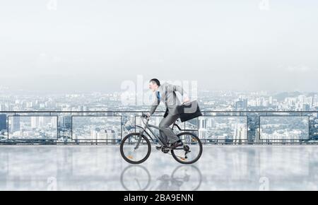 Man riding bicycle on penthouse balcony Stock Photo
