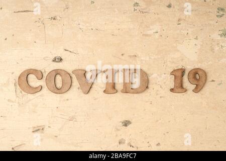 Epidemic corona virus covid 19 written with carved wooden letters on table Stock Photo
