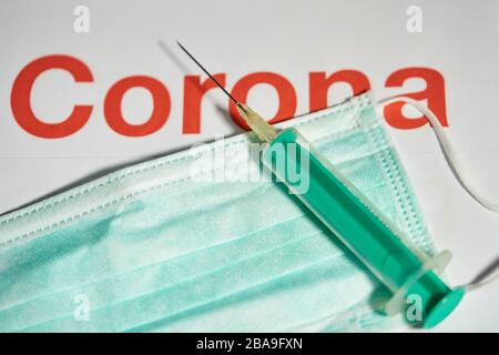Covid-19 symbol in  Marktoberdorf, Germany, March 26, 2020. Syringe for injection with needle for vaccination and a mouth protection due to the Corona virus disease (COVID-19)  on March 26, 2020 in Marktoberdorf, Germany  © Peter Schatz / Alamy Live News Stock Photo