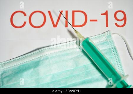 Covid-19 symbol in  Marktoberdorf, Germany, March 26, 2020. Syringe for injection with needle for vaccination and a mouth protection due to the Corona virus disease (COVID-19)  on March 26, 2020 in Marktoberdorf, Germany  © Peter Schatz / Alamy Live News Stock Photo