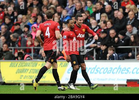 Manchester United's Patrice Evra (centre) celebrates scoring his teams first goal of the game with teammates Robin van Persie (right) and Phil Jones (left) Stock Photo