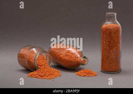 Health Food Ingredients - seeds jars, red lentils on grey paper Stock Photo