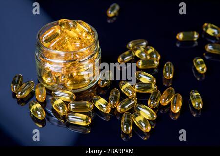 Omega fish oil softgels dietary supplement in jar. Healthy life and heart health concept. Focus on pills in jar Stock Photo