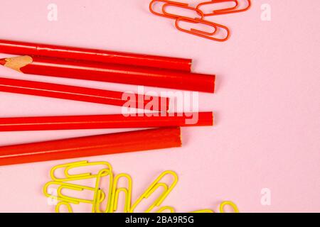 Multi-colored red pencils rulers, pens, pencils and scissors and stationery stand on a pink background Stock Photo