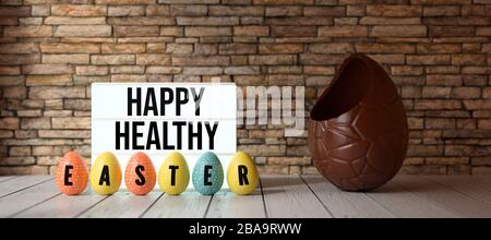 easter eggs with message HAPPY HEALTHY EASTER with big chocolate egg in front of a brick wall - 3D rendered illustration Stock Photo
