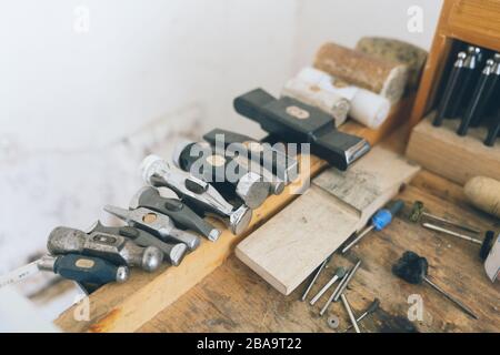 Rack of assorted hammer heads ranging from size aside other tools Stock Photo
