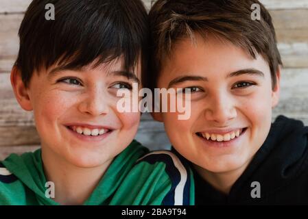 Close up of two smiling boys with their heads close together. Stock Photo