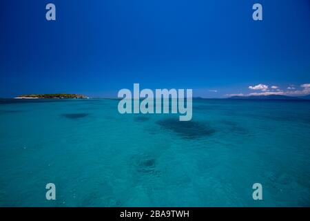 Green island seen in the distance from beautiful green/turquoise waters of Green Barrier Reef, Australia Stock Photo