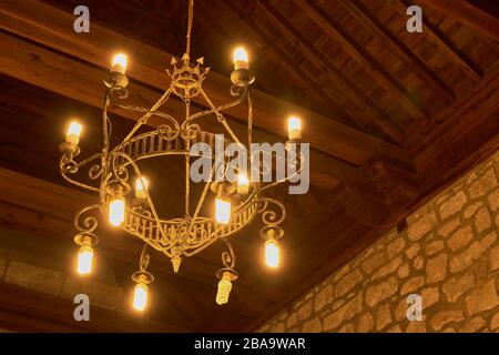 Close-up from inside the church with lighted lamps and  roof with wooden beams in the background in Las Ventas con Peña Aguilera, Toledo, Spain Stock Photo