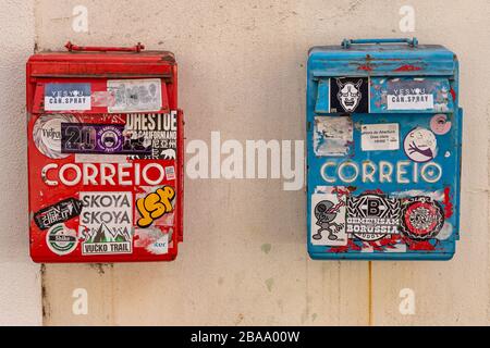 Lisbon, Portugal - 8 March 2020: Two red and blue mailboxes covered with stickers Stock Photo