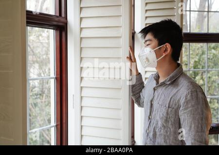 Wearing a mask of the boy looked out through the window Stock Photo - Alamy