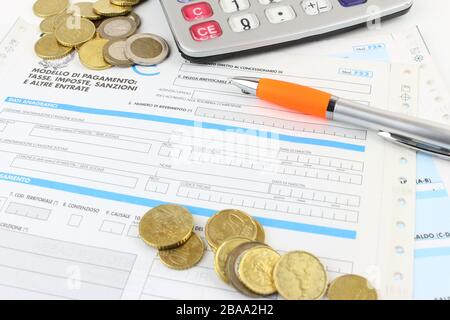 Form F23 / F24 to pay taxes in Italy to the bank. Detail with calculator and euro coins. Stock Photo