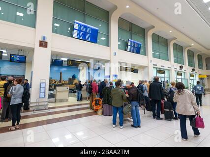 Domestic terminal check-in desks with passengers lined up in the interior of Islam Karimov Tashkent International Airport in Uzbekistan. Stock Photo