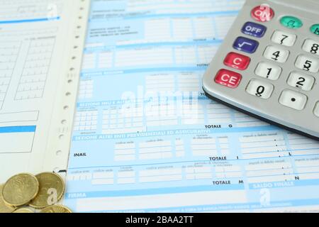 Form F23 / F24 to pay taxes in Italy to the bank. Detail with calculator and euro coins. Stock Photo