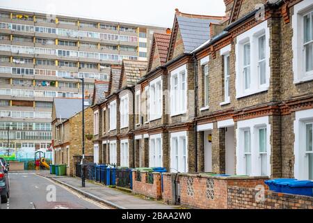 Traditional English terraced houses with huge council block Aylesbury Estate in the background in south east London Stock Photo