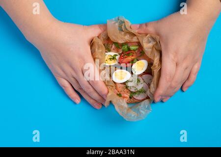 The cook is holding raw quail eggs on blue table Stock Photo