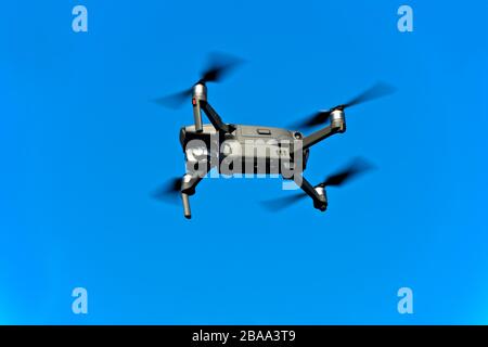 Drone in flight against the blue sky Stock Photo
