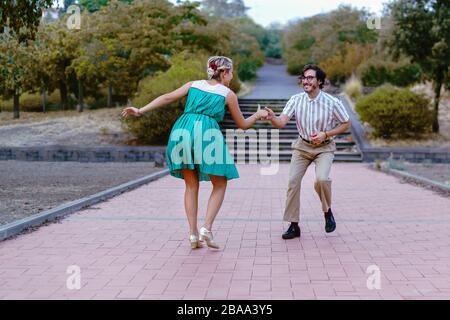 Couple dancing swing lindy-hop in outdoor in the park. People having fun dancing vintage music together in the nature. Stock Photo