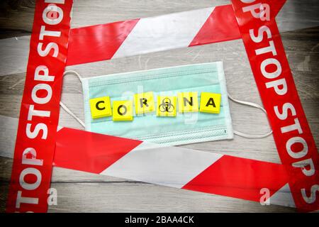 Corona stroke on mask and stop tape, symbolic photo Coronavirus, Corona-Schriftzug auf Mundschutz und Absperrband, Symbolfoto Coronavirus Stock Photo