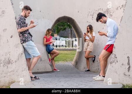 A group of young boys dependent on social media and the internet. Isolation and dependance of new technologies concept composition. Stock Photo