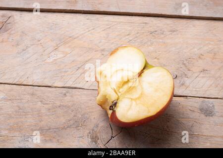 a bitten apple on a wooden table, horizontal Stock Photo