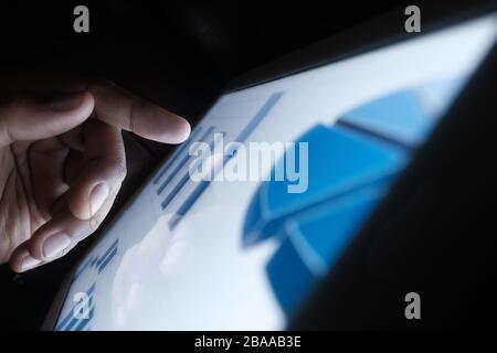 Close up of man hand analyzing chart on digital tablet  Stock Photo