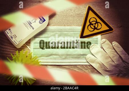 PHOTOMONTAGE, mask with stroke quarantine, stop tape, biology danger sign, protective gloves and disinfectants on a table, symbolic photo Coronavirus, Stock Photo