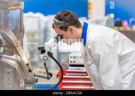 using a microscope while working in a research center Stock Photo