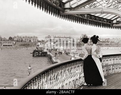 Two women look down on Clacton pier at Clacton-on-Sea, Essex, England towards the end of the 19th century.  After a print by an unknown photographer. Stock Photo