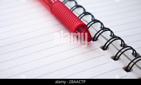 Close up - notebook and red pencil. Spiral notepad paper. Stock Photo