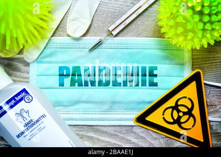 PHOTOMONTAGE, mask with the stroke pandemic, biology danger sign, protective gloves, clinical thermometers and disinfectants on a table, symbolic phot Stock Photo