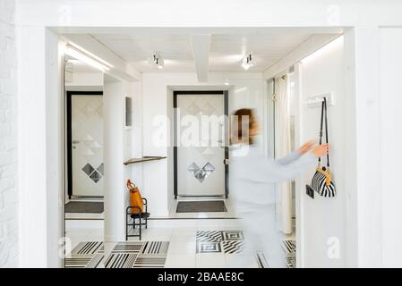 Interior view of the bright and modern apartment hallway with a blurred in motion human figure Stock Photo