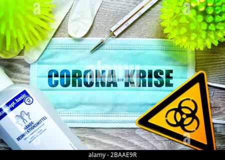 PHOTOMONTAGE, mask with the stroke Corona crisis, biology danger sign, protective gloves, clinical thermometers and disinfectants on a table, symbolic Stock Photo