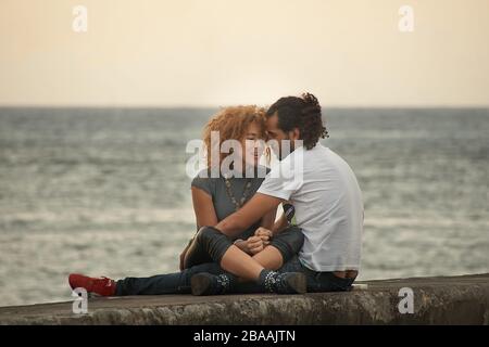 Romantic cuban boyfriend and girlfriend in embrace on Malecon seawall Stock Photo