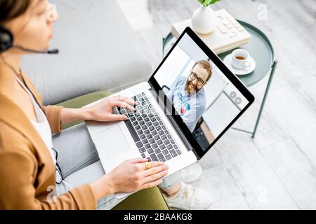 Business woman having a video call with coworker, working online from home at cozy atmosphere. Concept of remote work from home Stock Photo