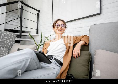 Portrait of a young creative woman as a web designer or artist, working on a digital tablet at home. Concept of a freelance and creative work online Stock Photo