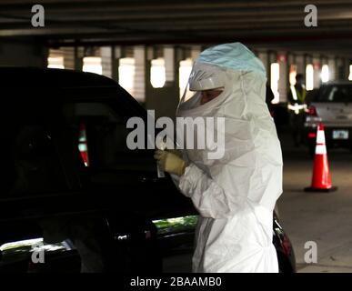 A Florida National Guard member takes a nasal swab from a citizen at a COVID-19 Community-Based Drive Through Testing Site at the Orange County Convention Center March 26, 2020 in Orlando, Florida. Stock Photo