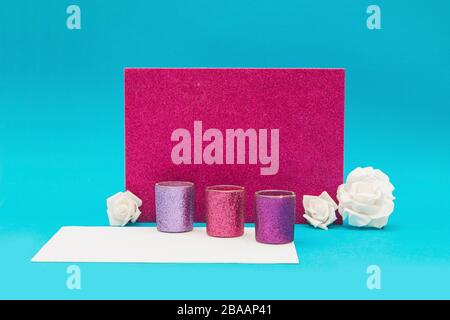 Purple shiny candle holders with roses on a blue and white background Stock Photo