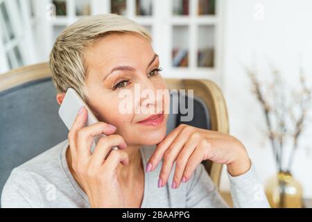 Serene female with a smartphone looking away Stock Photo