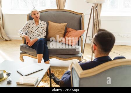 Short-haired doctor listening to his female patient Stock Photo