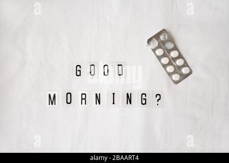 Question Good morning, pills in blister pack on crumpled white sheet. Awakening concept with headache, fever, medicine, illness, health, hangover, mig Stock Photo