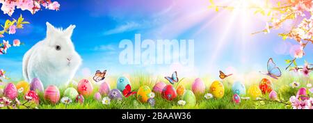 Adorable Bunny With Easter Eggs And Flowers On Grass Stock Photo