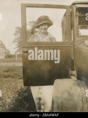 Antique circa 1924 photograph, a woman stands in front of an open car door. Exact location unknown; probably Rhode Island. SOURCE: ORIGINAL PHOTOGRAPH Stock Photo