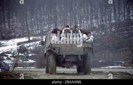 26th January 1994 During the war in central Bosnia: soldiers of the HVO's Rama Brigade ride in the back of a truck after some intense fighting in the village of Here. Stock Photo