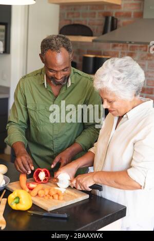 Senior african american couple cooking together in kitchen using tablet ...