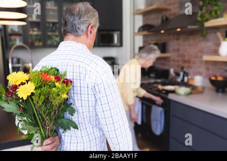 Caucasian senior offering flowers to his wife Stock Photo