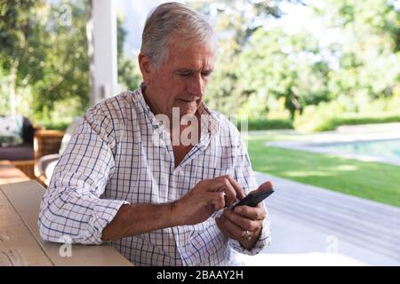 Caucasian senior using smartphone at home Stock Photo
