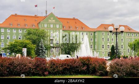 Szczecin, Poland, June 2018 Green buildings of Stettin City Council with fountains and red hedge, petitioners going in and out Stock Photo