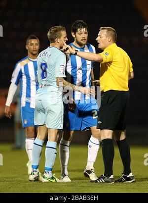 Coventry City's Carl Baker (left) and Colchester United's Anthony Wordsworth (centre right) speak with referee Trevor Kettle (right) following a first-half decision Stock Photo
