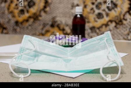 On a dark table are a protective mask against viruses with the inscription 2019-nCoV and medical syringes. Virus Prevention Stock Photo